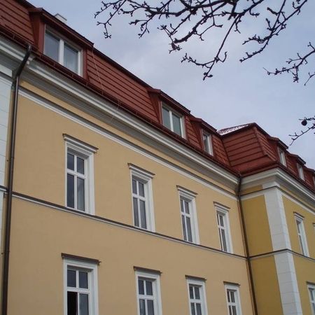 Ein Haus mit gelber Wandfarbe und rotem Dach