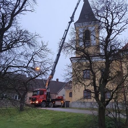 Mittels Kran wird ein Kreuz auf dem Dach einer Kirche erreicht