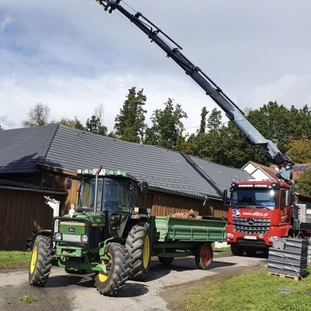 Arbeiten an einem Dach mithilfe eines Kran-Arms