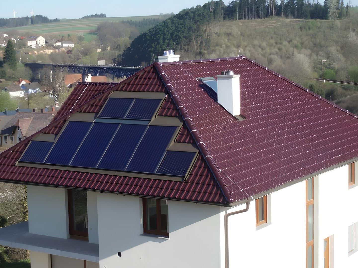 Ein dunkelrotes Dach mit montierten Solar-Modulen